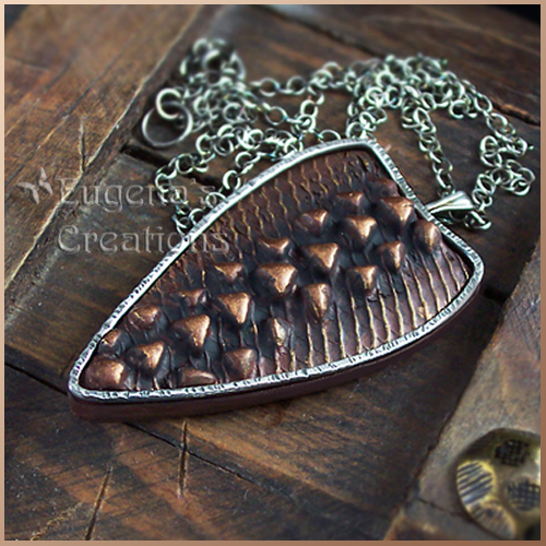 Silver-framed polymer clay pendant with dragonhide texture and silver bezel